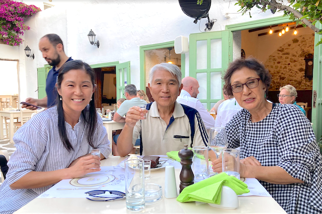 My parents and I celebrating my dad's birthday in a beautiful restaurant with an outdoor patio in Naxos, Greece.